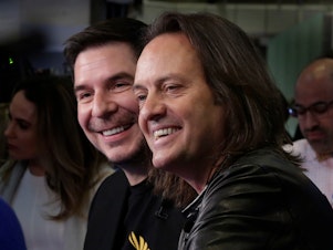 caption: Sprint CEO Marcelo Claure (left) and T-Mobile CEO John Legere on the floor of the New York Stock Exchange on April 30, 2018.