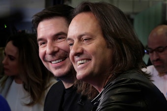 caption: Sprint CEO Marcelo Claure (left) and T-Mobile CEO John Legere on the floor of the New York Stock Exchange on April 30, 2018.