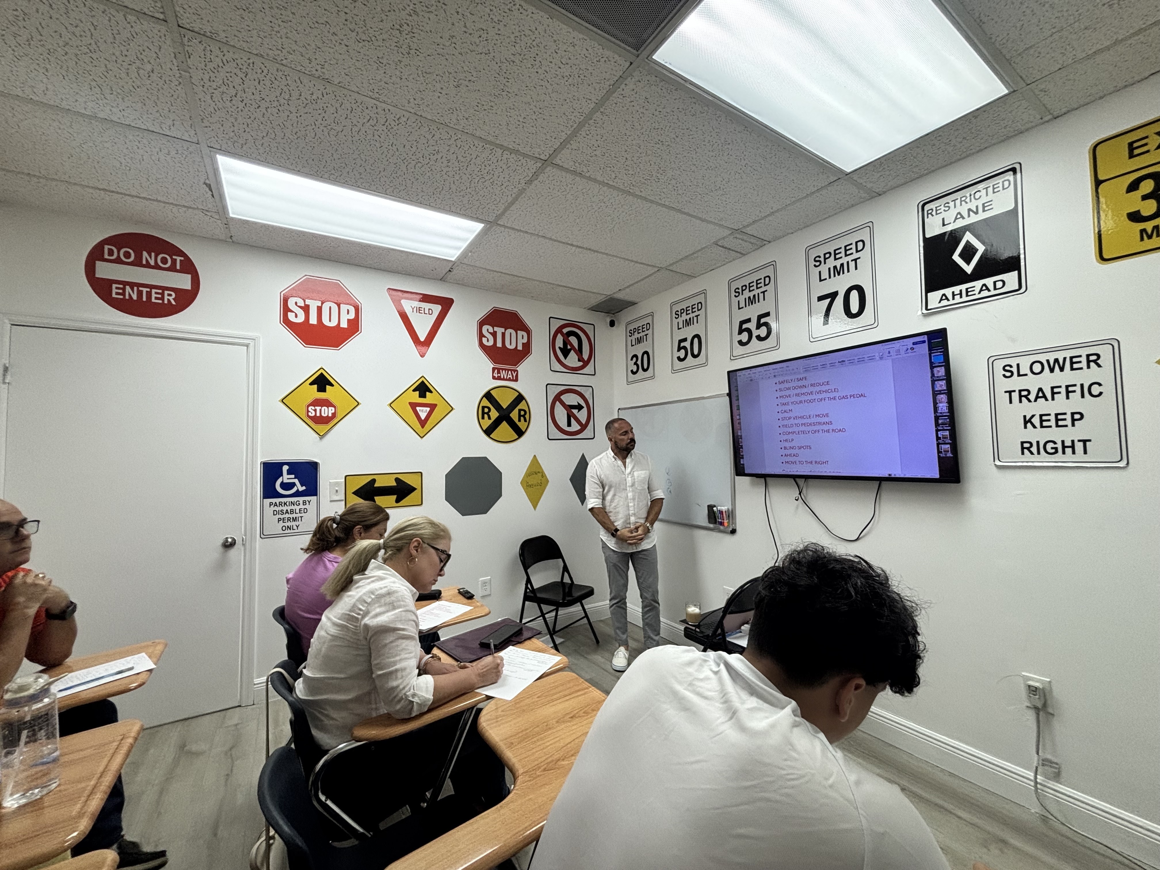 caption: Johannes González, an instructor at Speedway Driving School in Hialeah, Florida, teaches Spanish-speaking students to memorize key words in order to pass the state's new English-only driving exam.