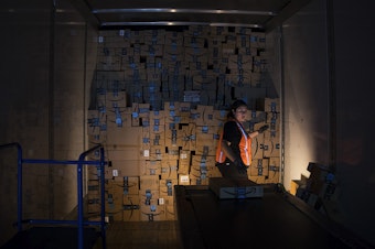 caption: Amazon employee Andrea Neri stacks boxes in the back of a delivery truck on the ship dock at an Amazon fulfillment center on Friday, November 3, 2017, in Kent. 