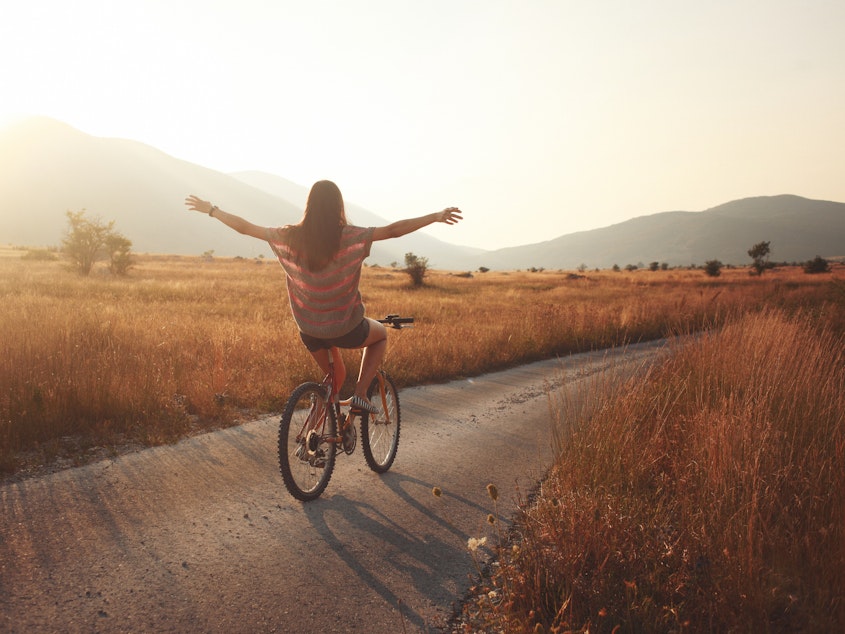 vintage toned young brunette on a bicycle, lit by the Autumn sunset.