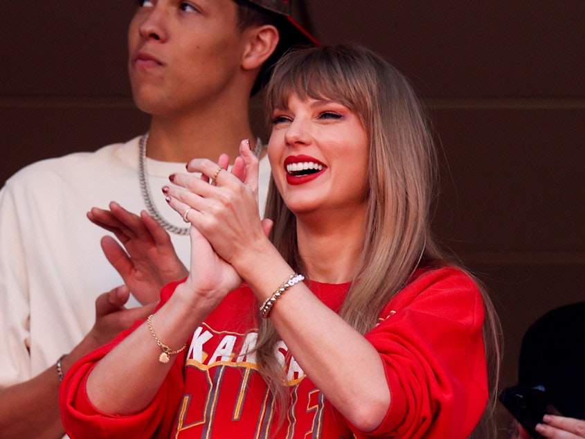 caption: Taylor Swift reacts during a game between the Los Angeles Chargers and Kansas City Chiefs at Arrowhead Stadium in Kansas City, Missouri on October 22, 2023.