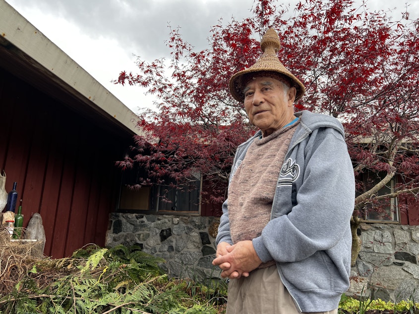 caption: Ed Carriere pictured in front of his house in Indianola. Carriere has made thousands of baskets since he first learned from his great grandmother, Julia Jacobs. He's wearing a hand-woven hat he made in the style of New Zealand weavers.