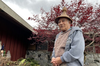 caption: Ed Carriere pictured in front of his house in Indianola. Carriere has made thousands of baskets since he first learned from his great grandmother, Julia Jacobs. He's wearing a hand-woven hat he made in the style of New Zealand weavers.