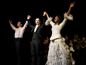 caption: John Riddle as Raoul, Laird Mackintosh as the Phantom and Emilie Kouatchou as Christine, take a bow at the end of the final performance of the <em>Phantom of the Opera</em> at the Majestic Theater in New York City on April 16, 2023.