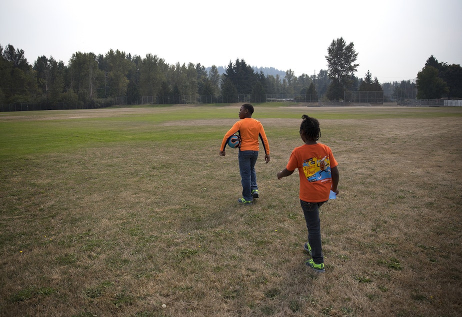 caption: Matthew Hicks, 9, and Mariah Hicks, 7, walk into a field adjacent to their new apartment to play soccer, on Saturday, September 16, 2017, in Auburn.