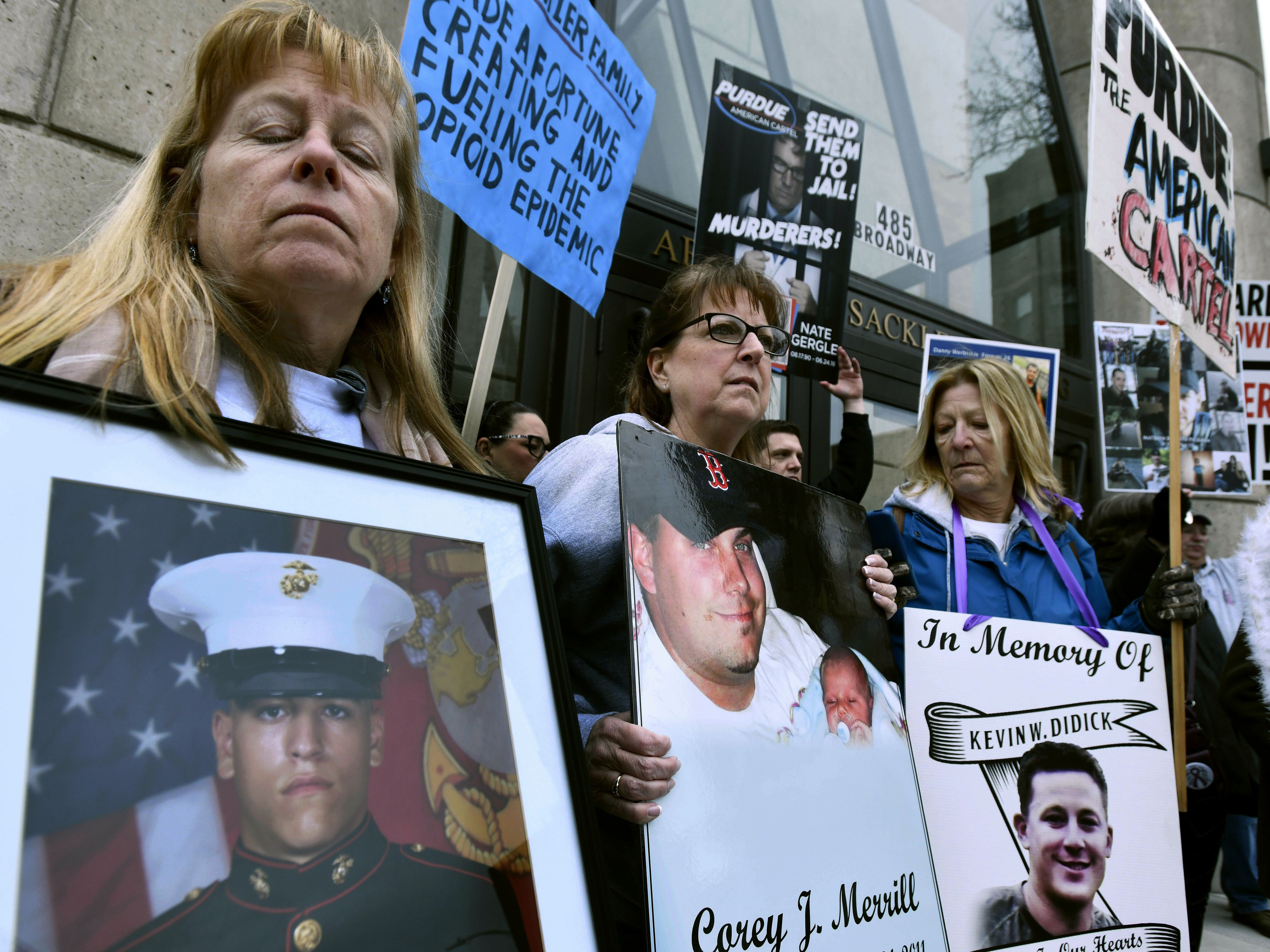 caption: Kathleen Scarpone, left, of Kingston, N.H., and Cheryl Juaire, second from left, of Marlborough, Mass., protest in front of the Arthur M. Sackler Museum, at Harvard University, April 12, 2019, in Cambridge, Mass. Scarpone, who lost her son to OxyContin addiction, and Juarie addressed three Sackler family members during a virtual U.S. Bankruptcy Court hearing, Thursday, March 10, 2022.