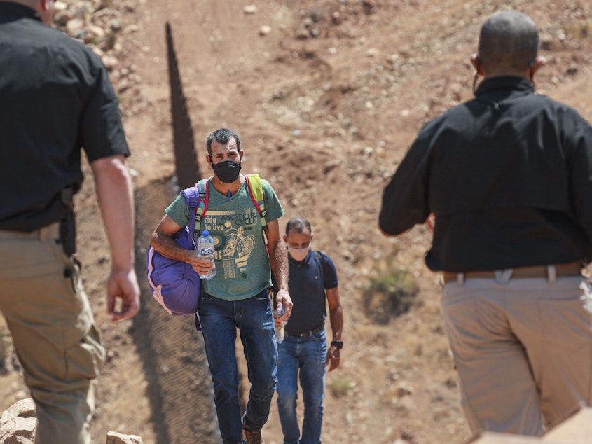 caption: Customs and Border Protection agents apprehend a group of Brazilian migrants in Otay Mesa, Calif., in August 2021.