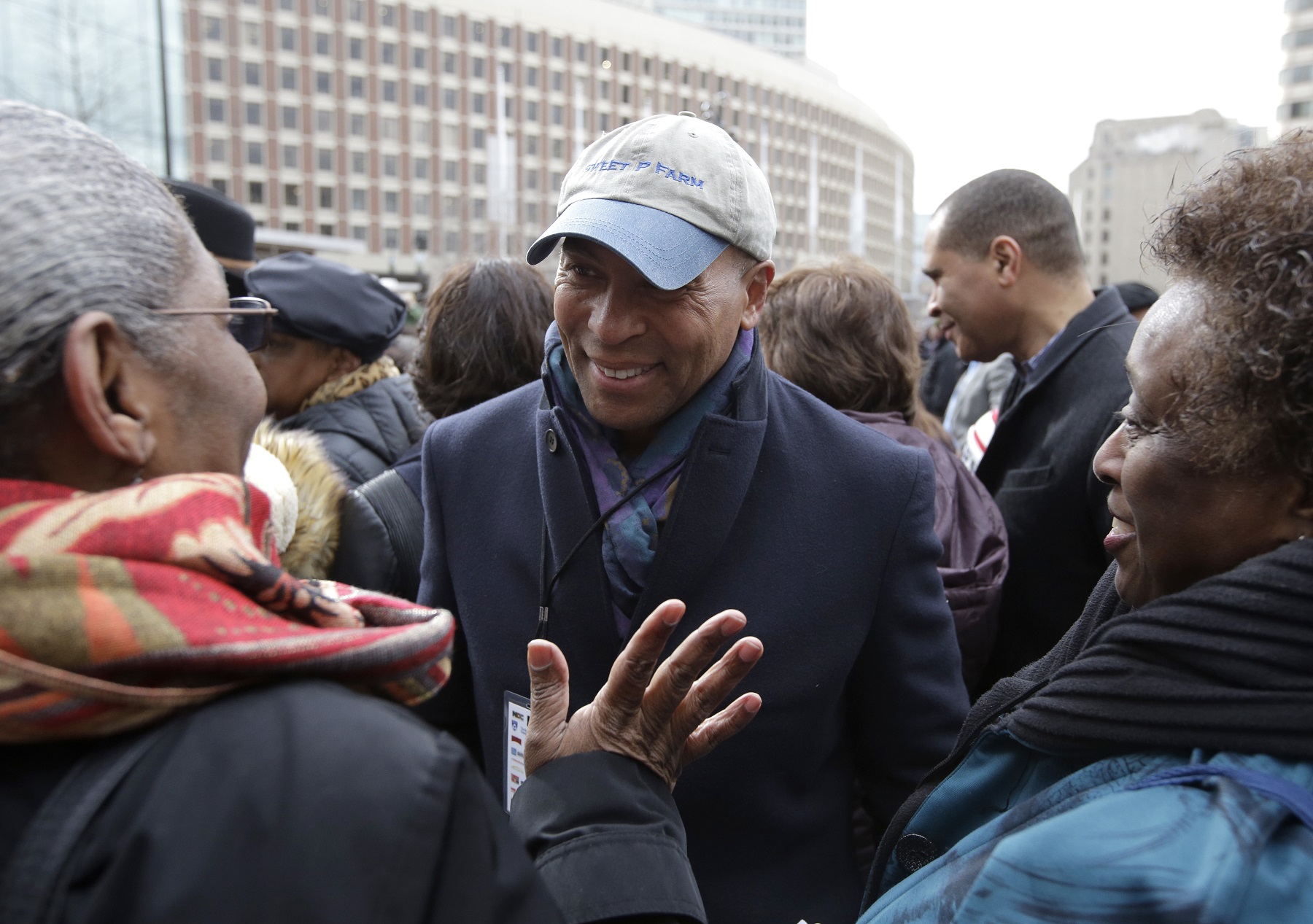 caption: Former Mass. Gov. Deval Patrick, center, greets people in a crowd, Monday, April 2, 2018, before a remembrance on City Hall Plaza, in Boston, for Martin Luther King Jr.