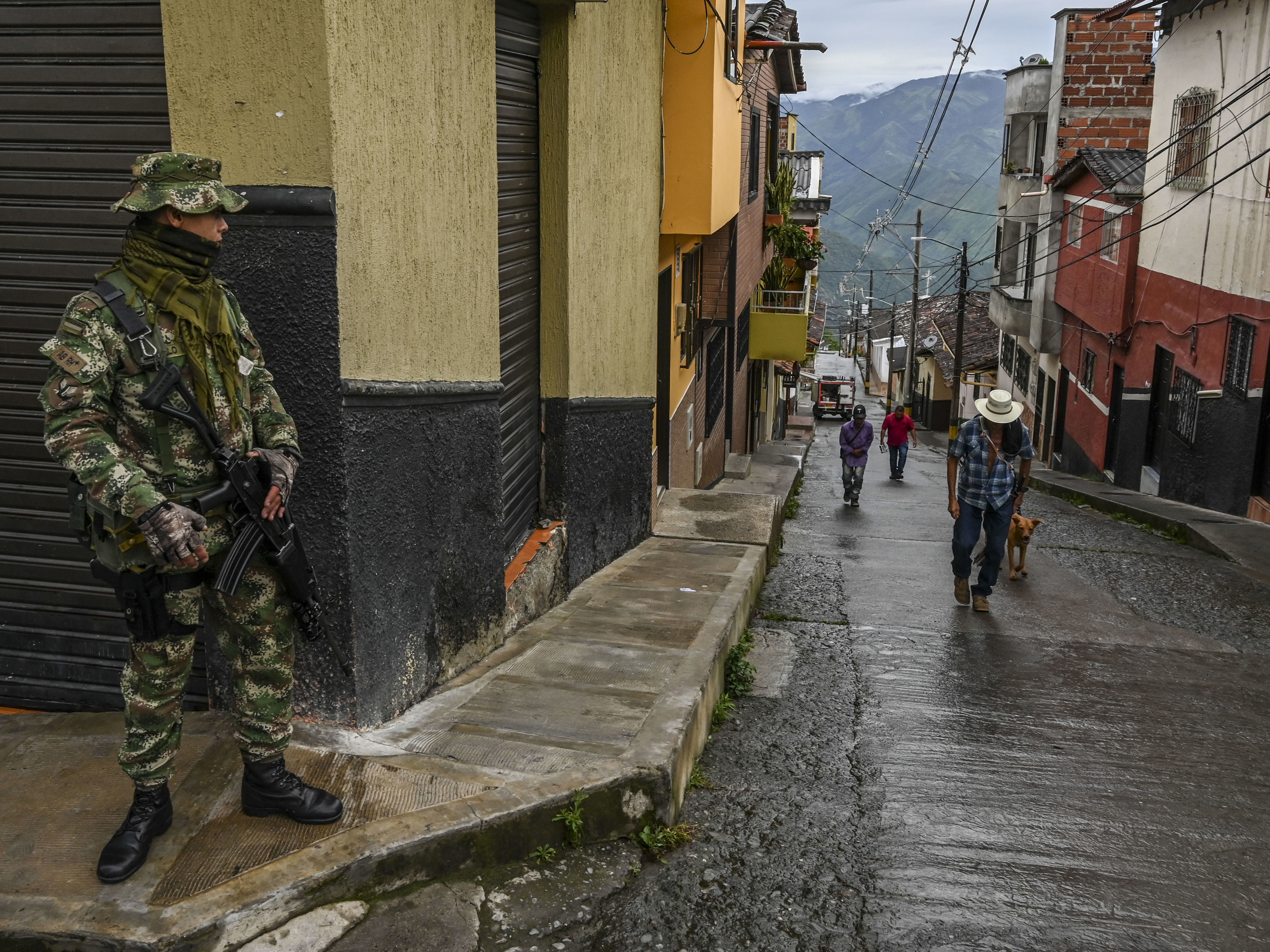 caption: A soldier stands guard on a street in Ituango, Colombia, on Oct. 19, 2019. The town is home to a new public radio station staffed by ex-FARC rebels and war victims. Reporters often conduct interviews with former combatants and update listeners on the progress and setbacks of Colombia's peace accords.