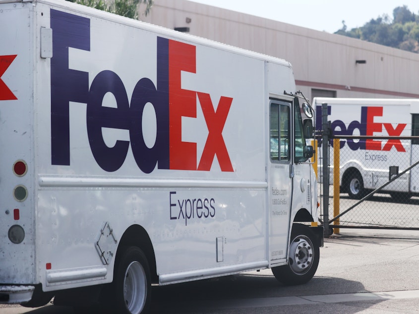 caption: FedEx trucks are parked at a FedEx Ship Center on September 22, 2021 in Los Angeles, California. FedEx says the driver who dumped packages into an Alabama ravine at least six times is no longer with the company.