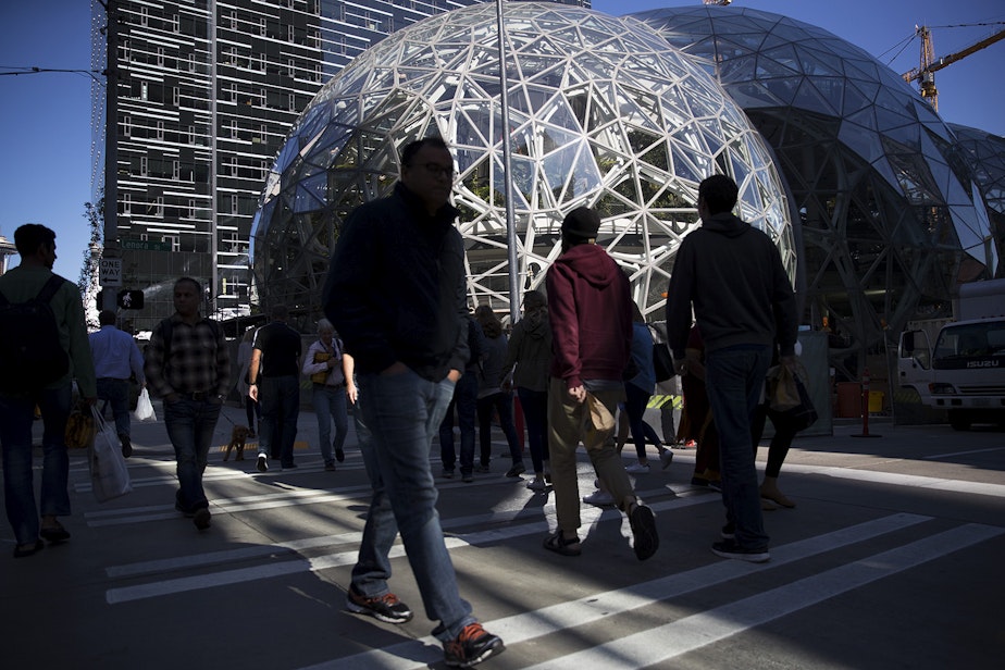 caption: A crowd is showing crossing the street in front of Amazon's biospheres during Amazon's bring your parents to work day on Friday, September 15, 2017, in Seattle.