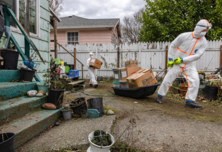 caption: Volunteer military veterans with Team Rubicon help clean up debris in Seattle's South park neighborhood following massive flooding in December 2022.