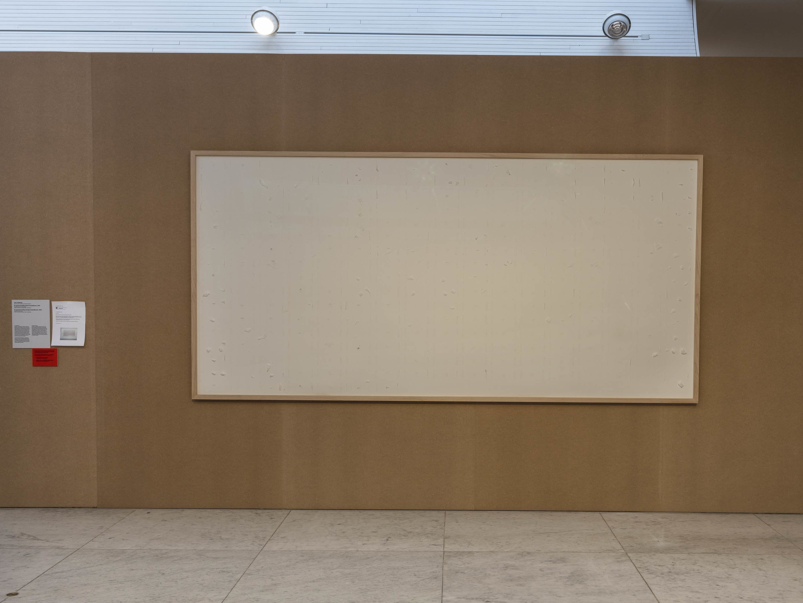 caption: Jens Haaning's artwork "Take the Money and Run" is seen in the Kunsten Musem of Modern Art. The empty canvas was meant to hold thousands of dollars in cash — but the artist chose to hang on to the money.