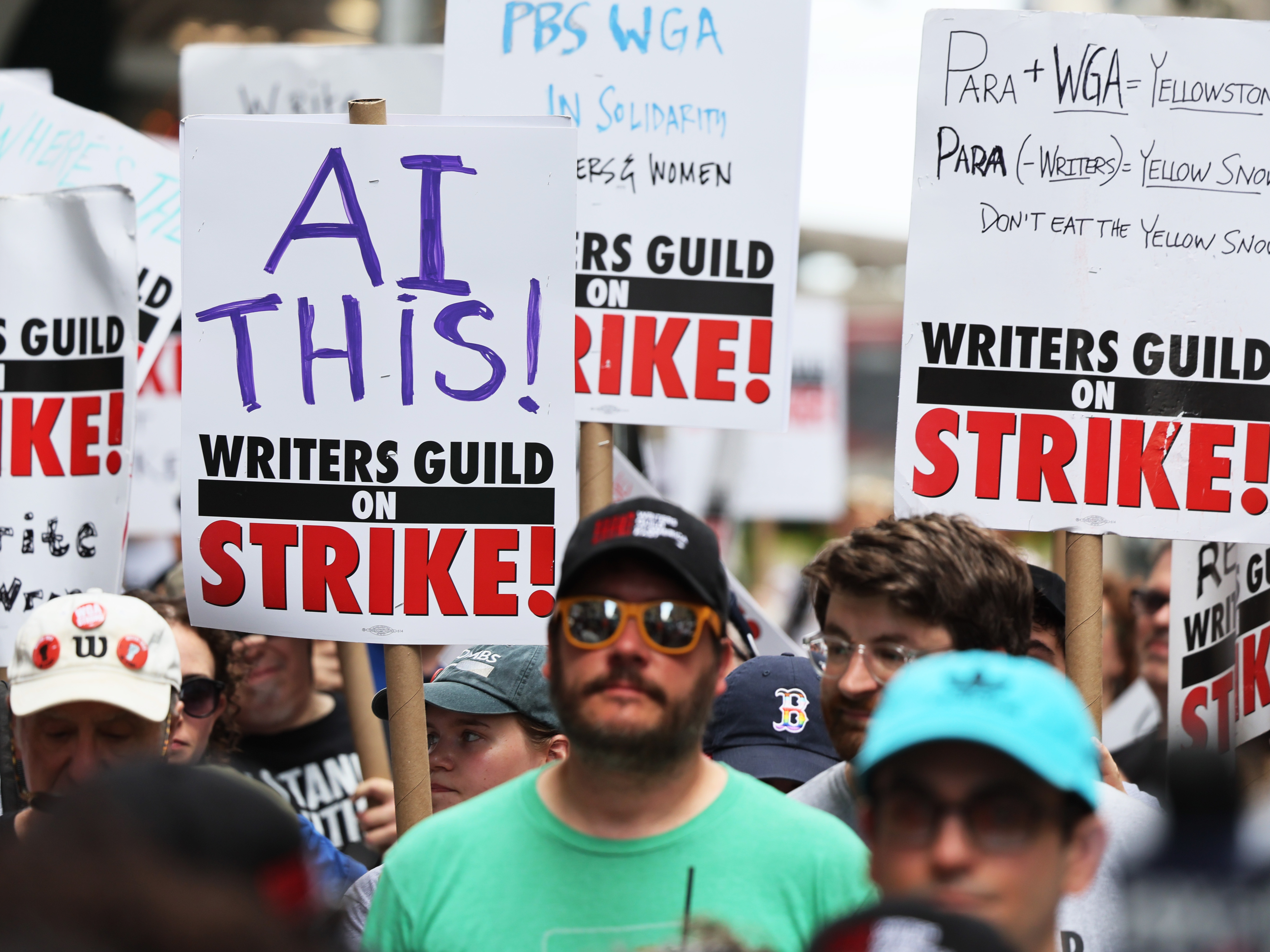 caption: Members of the Writers Guild of America East picket at the Warner Bros. Discovery NYC office on July 13, 2023 in New York City.