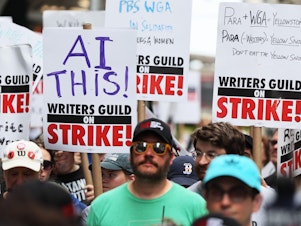 caption: Members of the Writers Guild of America East picket at the Warner Bros. Discovery NYC office on July 13, 2023 in New York City.