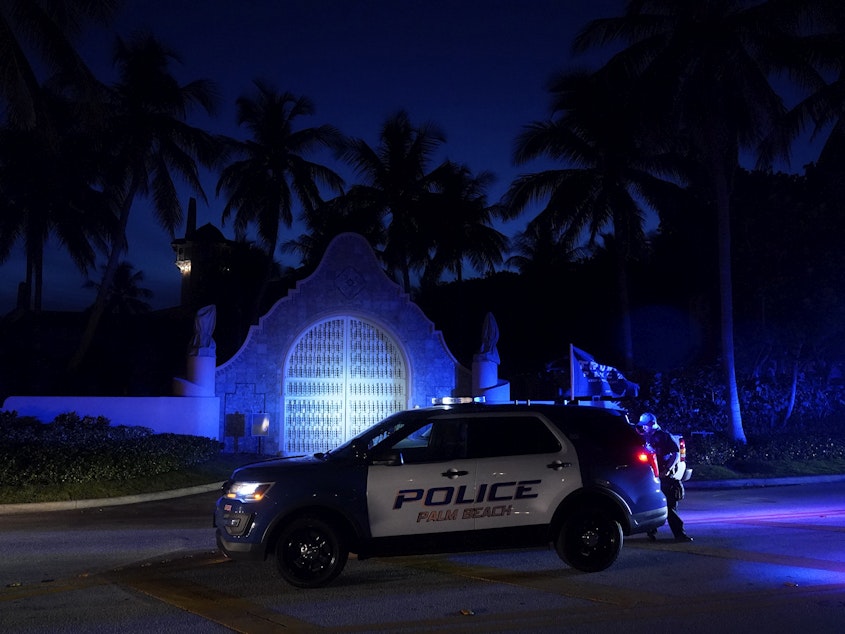 caption: Police stand outside an entrance to former President Donald Trump's Mar-a-Lago estate on Aug. 8, 2022, in Palm Beach, Fla.