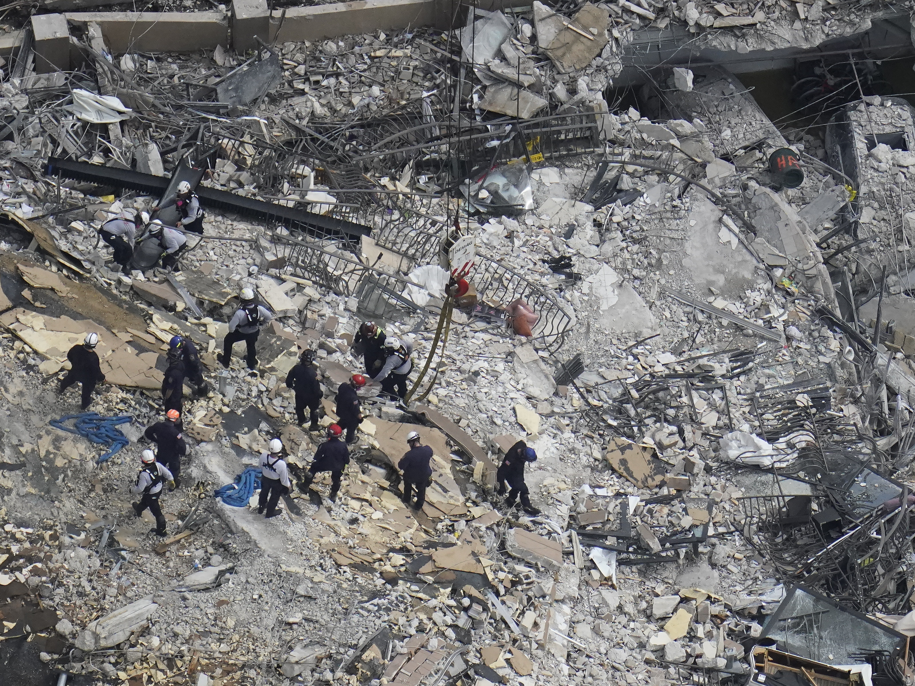 caption: Rescue workers search in the rubble at the Champlain Towers South condo in Surfside, Fla., on June 26.