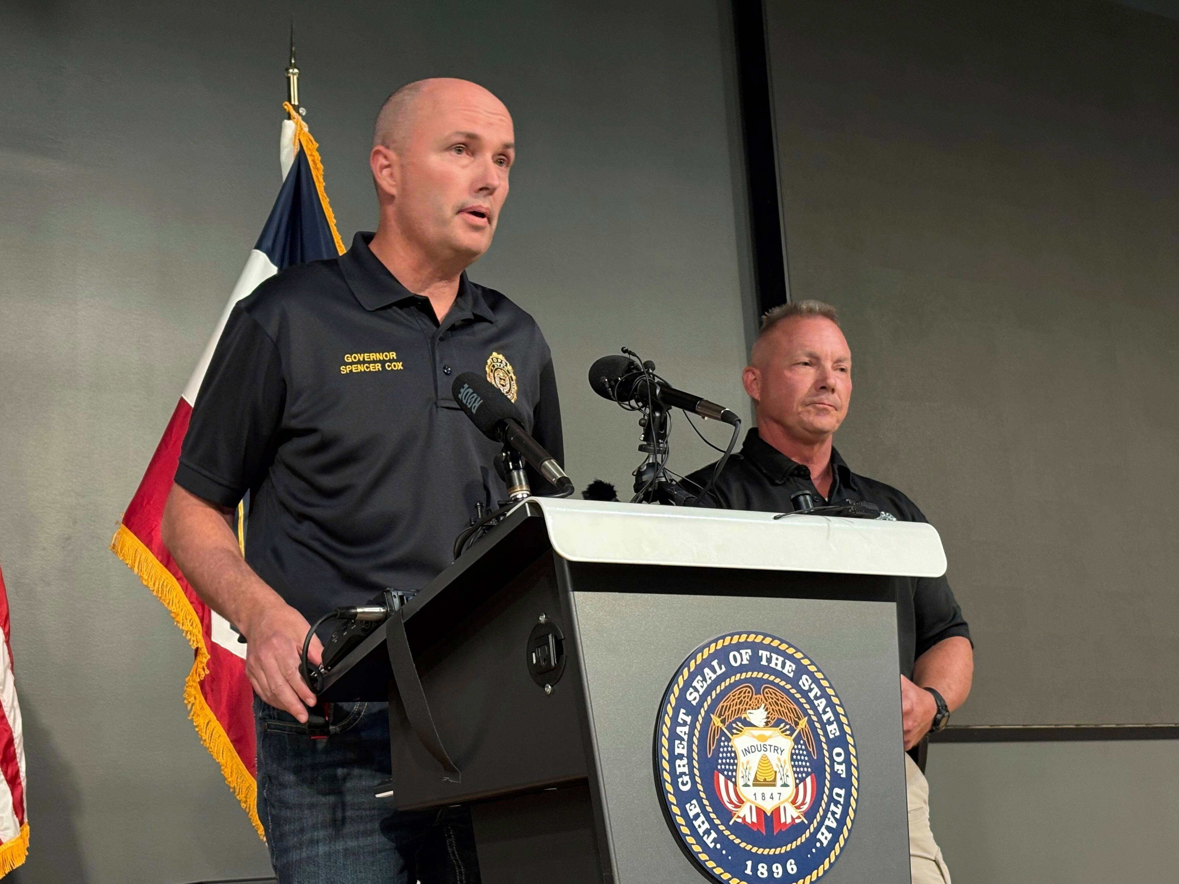 caption: Utah Gov. Spencer Cox, left, speaks with Utah Valley University Chief of Police Jeff Long, right, at a press conference on the campus after Charlie Kirk was shot and killed during an event Wednesday.