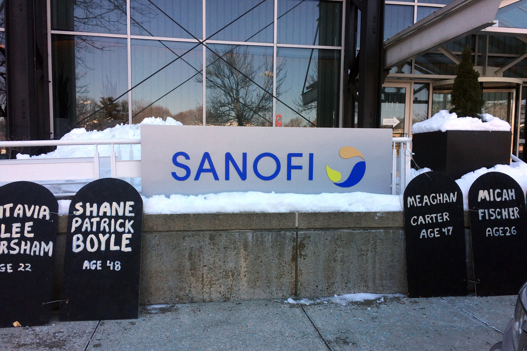 caption: Cardboard headstones line the sidewalk outside of pharmaceutical company Sanofi's Cambridge, Mass., offices. The Right Care Alliance held a protest against high insulin prices, which have led some to the dangerous practice of cutting doses to save. (Anna Bauman/On Point)