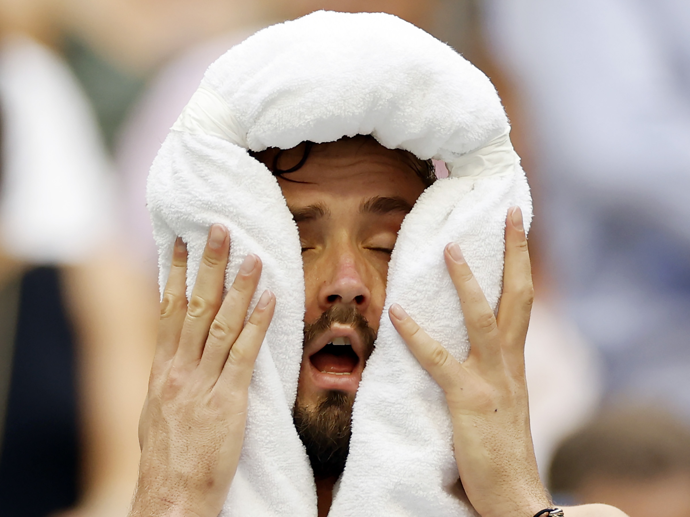 caption: Daniil Medvedev cools down against Andrey Rublev of Russia during their men's singles quarterfinal match.