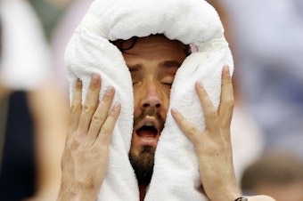 caption: Daniil Medvedev cools down against Andrey Rublev of Russia during their men's singles quarterfinal match.