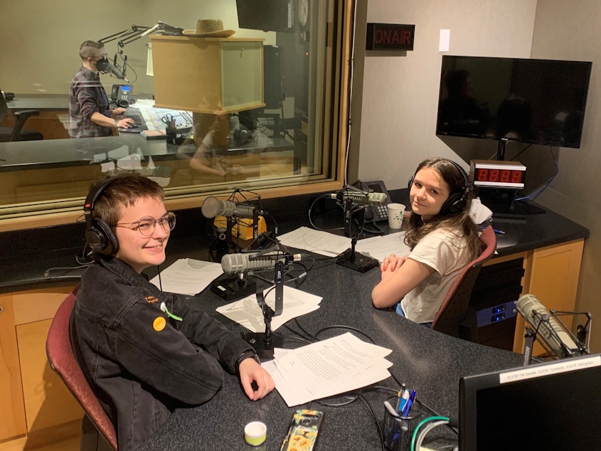 caption: Gideon Hall and Ada Walther, graduates of RadioActive's 2022 Intro to Radio Journalism Workshop and the hosts of this showcase, in the KUOW studios.