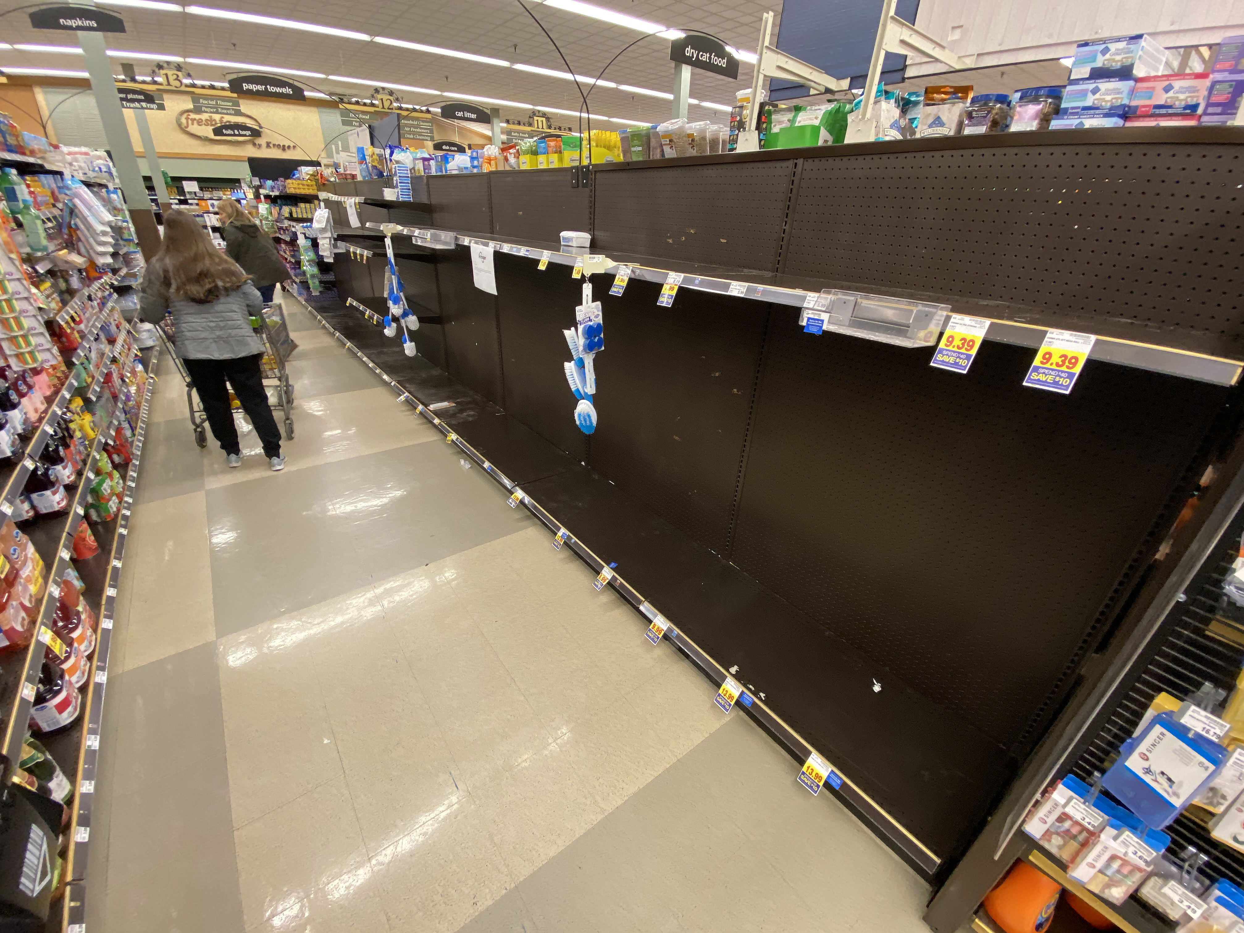 caption: Shoppers found some empty shelves at a Kroger grocery store in Grosse Ile, Mich., on Friday. Americans are stocking up on food, toilet paper, water and other items amid the coronavirus outbreak.