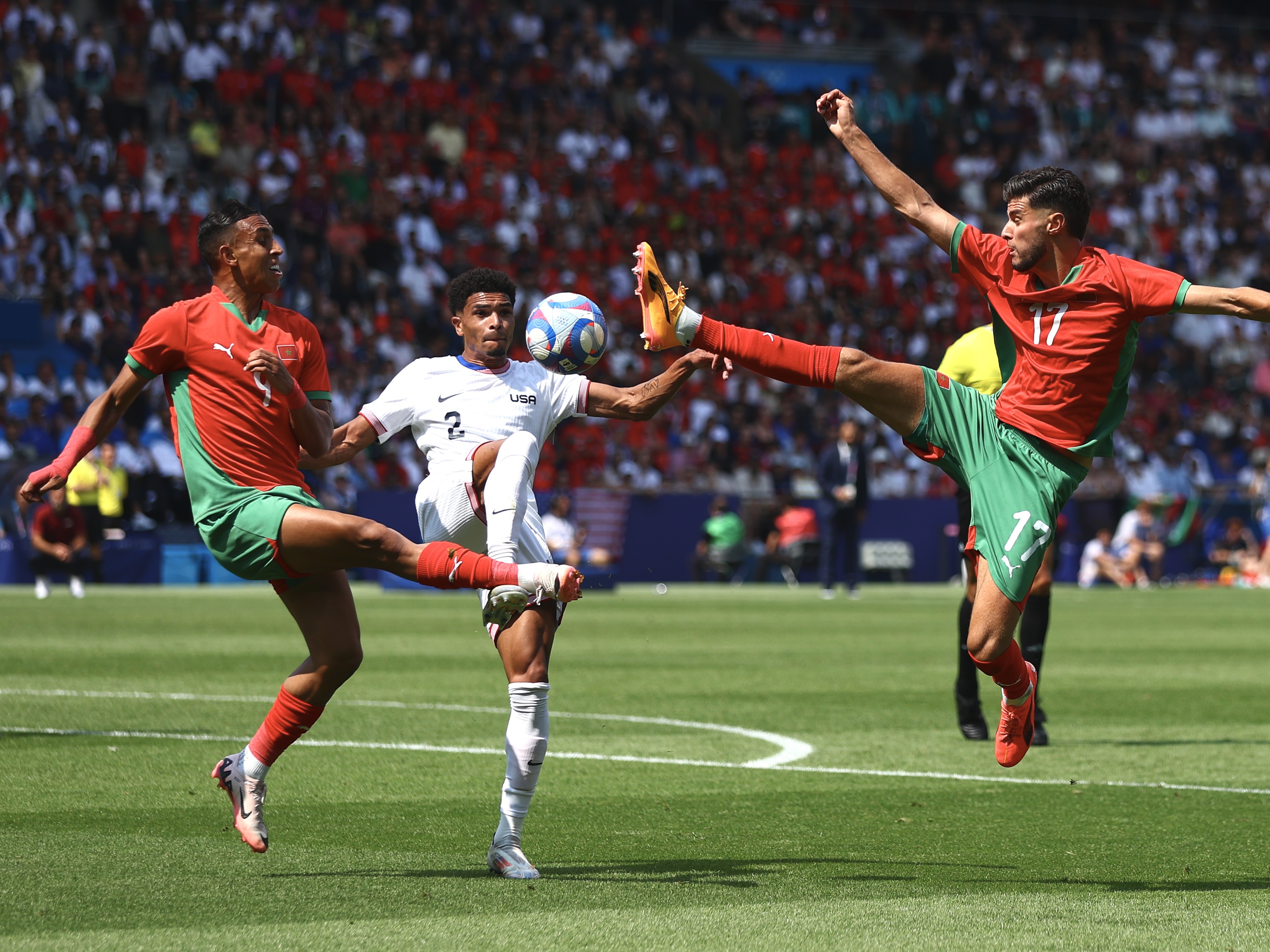 caption: Nathan Harriel (#2) of Team United States battles for the ball during the Paris Olympic quarterfinal match against Morocco on Friday at Parc des Princes stadium.