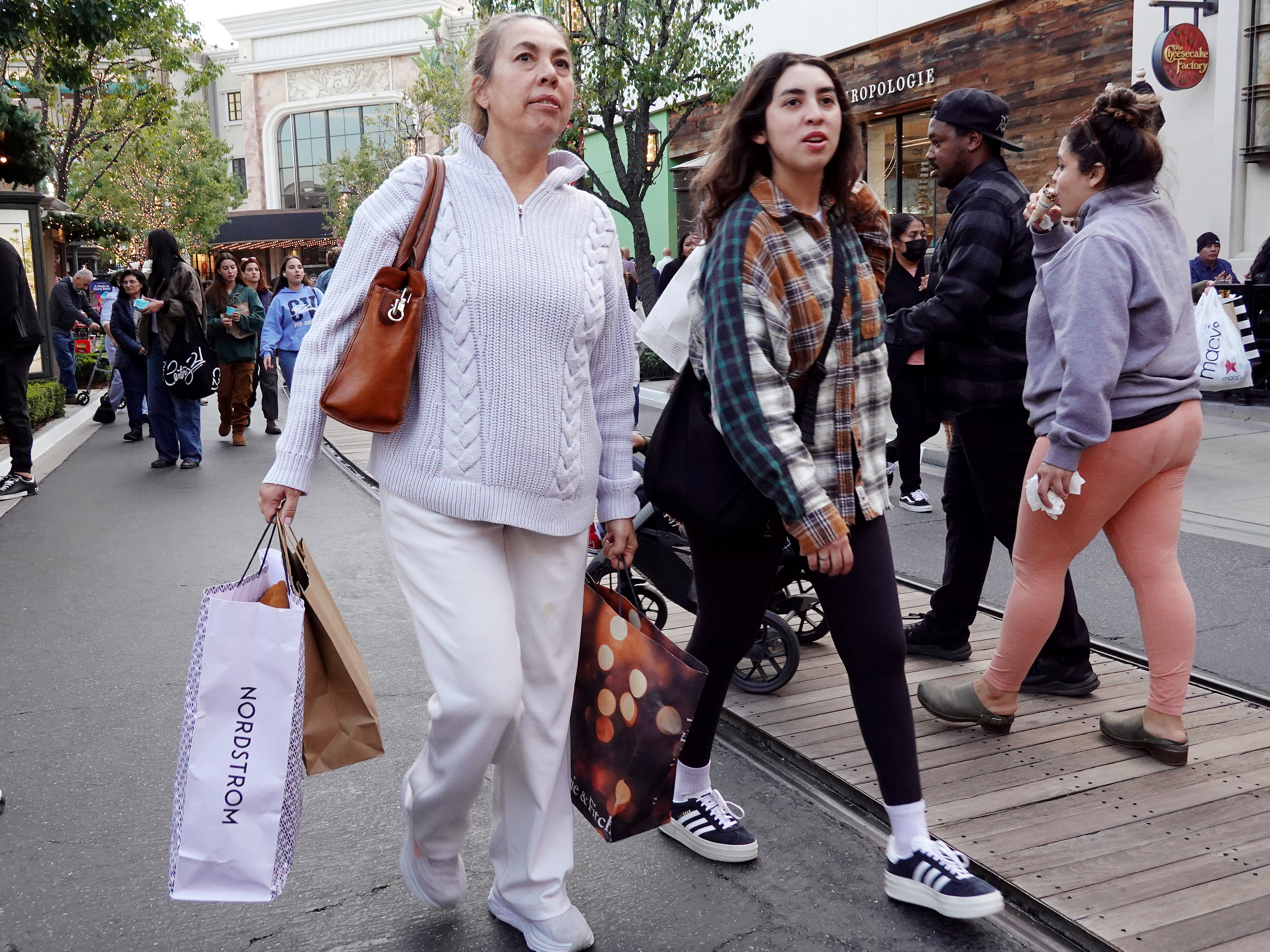 caption: A person carries shopping bags at a shopping center on the day after Christmas on Dec. 26, 2023 in Glendale, Calif. Strong consumer spending helped drive better-than-expected economic growth in the final months of 2023.