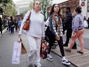 caption: A person carries shopping bags at a shopping center on the day after Christmas on Dec. 26, 2023 in Glendale, Calif. Strong consumer spending helped drive better-than-expected economic growth in the final months of 2023.