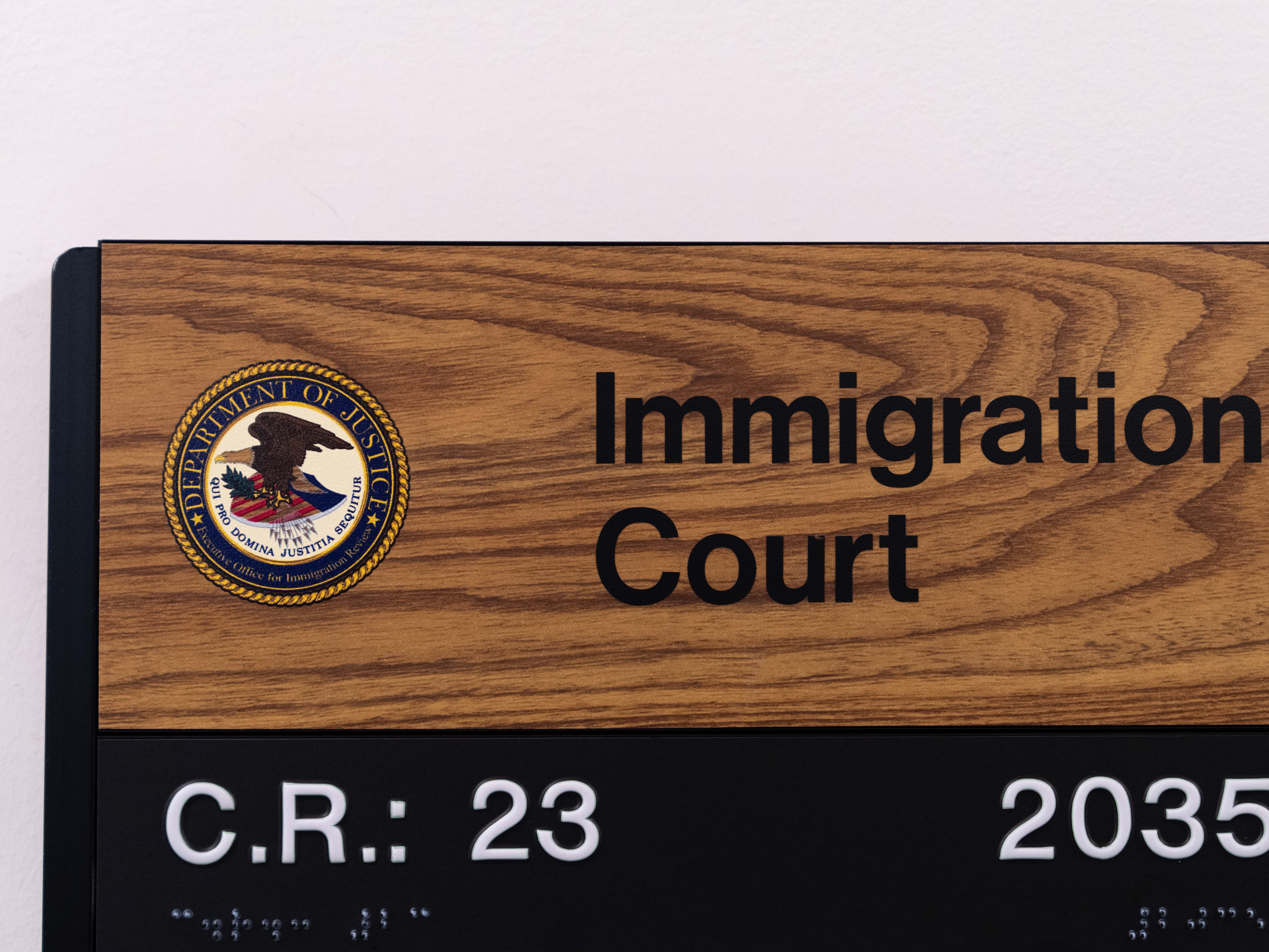 caption: In this file photo, a sign shows the location of an immigration court in New York City. In July, 16 more immigration judges were fired.
