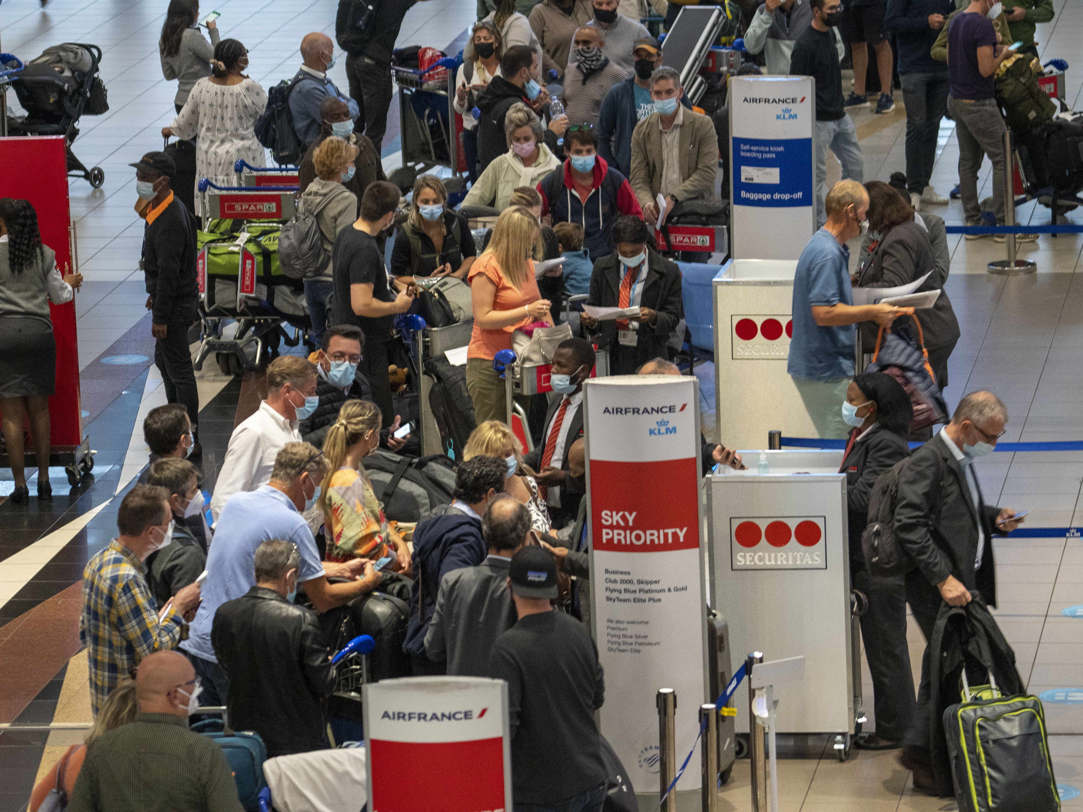 caption: People line up to get on an Air France flight to Paris at OR Tambo's airport in Johannesburg, South Africa, on Friday as several countries announced travel bans in response to the omicron variant of the coronavirus.