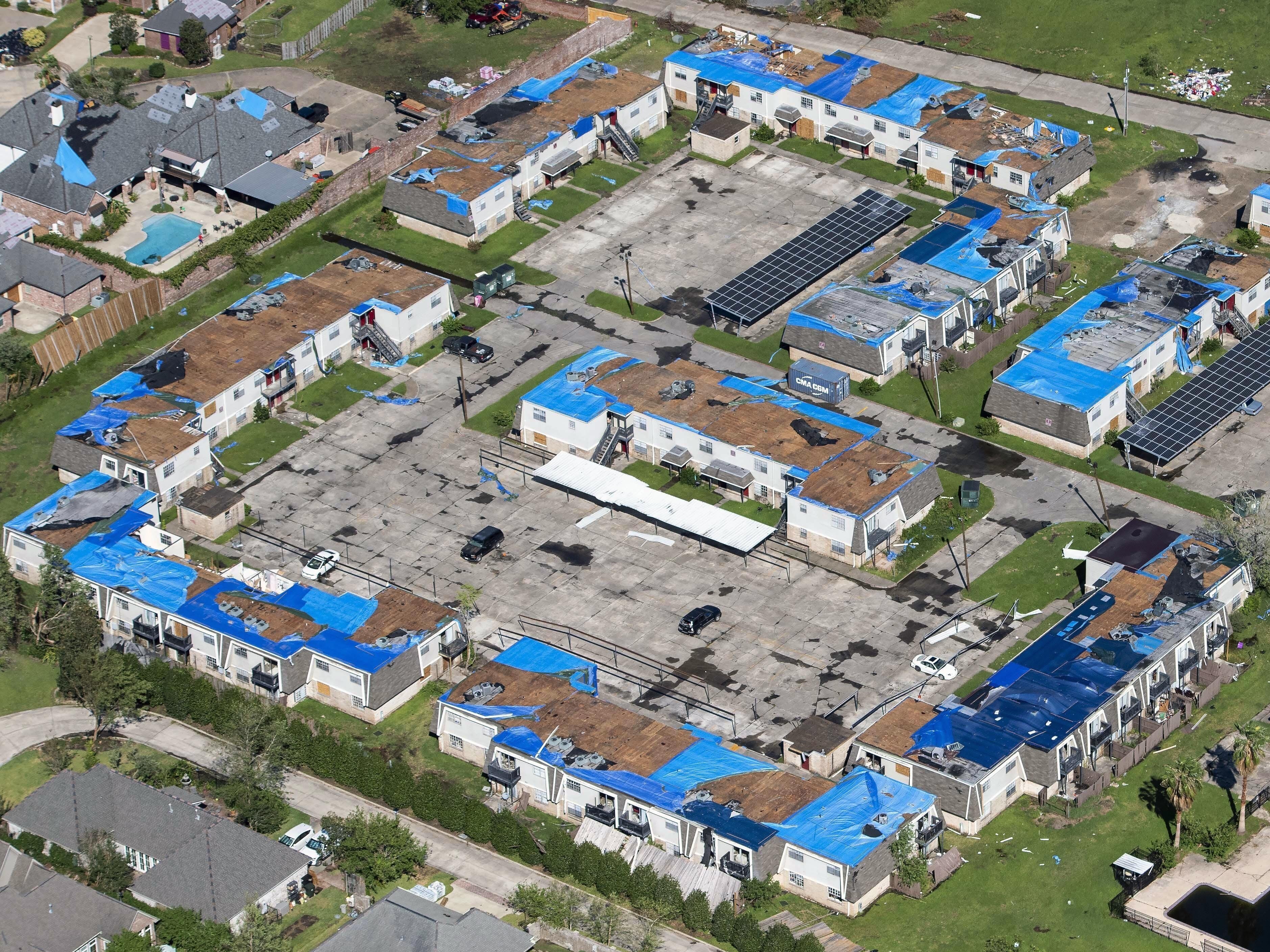 caption: Blue tarps cover houses with damaged roofs in Lake Charles, La., after Hurricane Delta hit the city in October 2020.