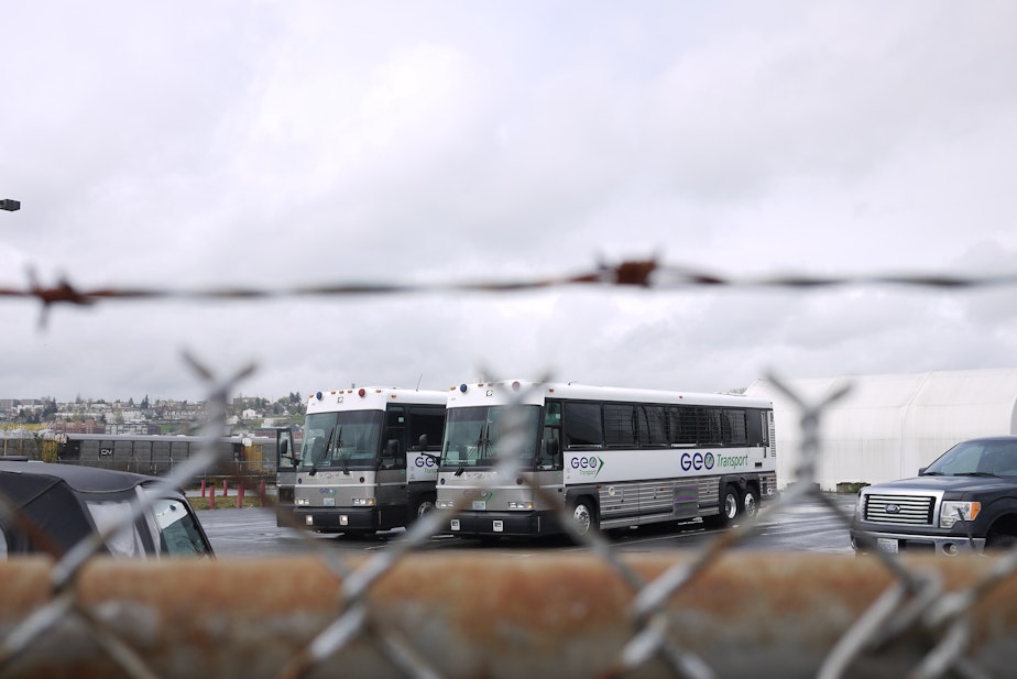 caption: Buses used to trasport detainees at the Northwest Detention Center in Tacoma. The center is operated by the GEO Group, a private contractor.