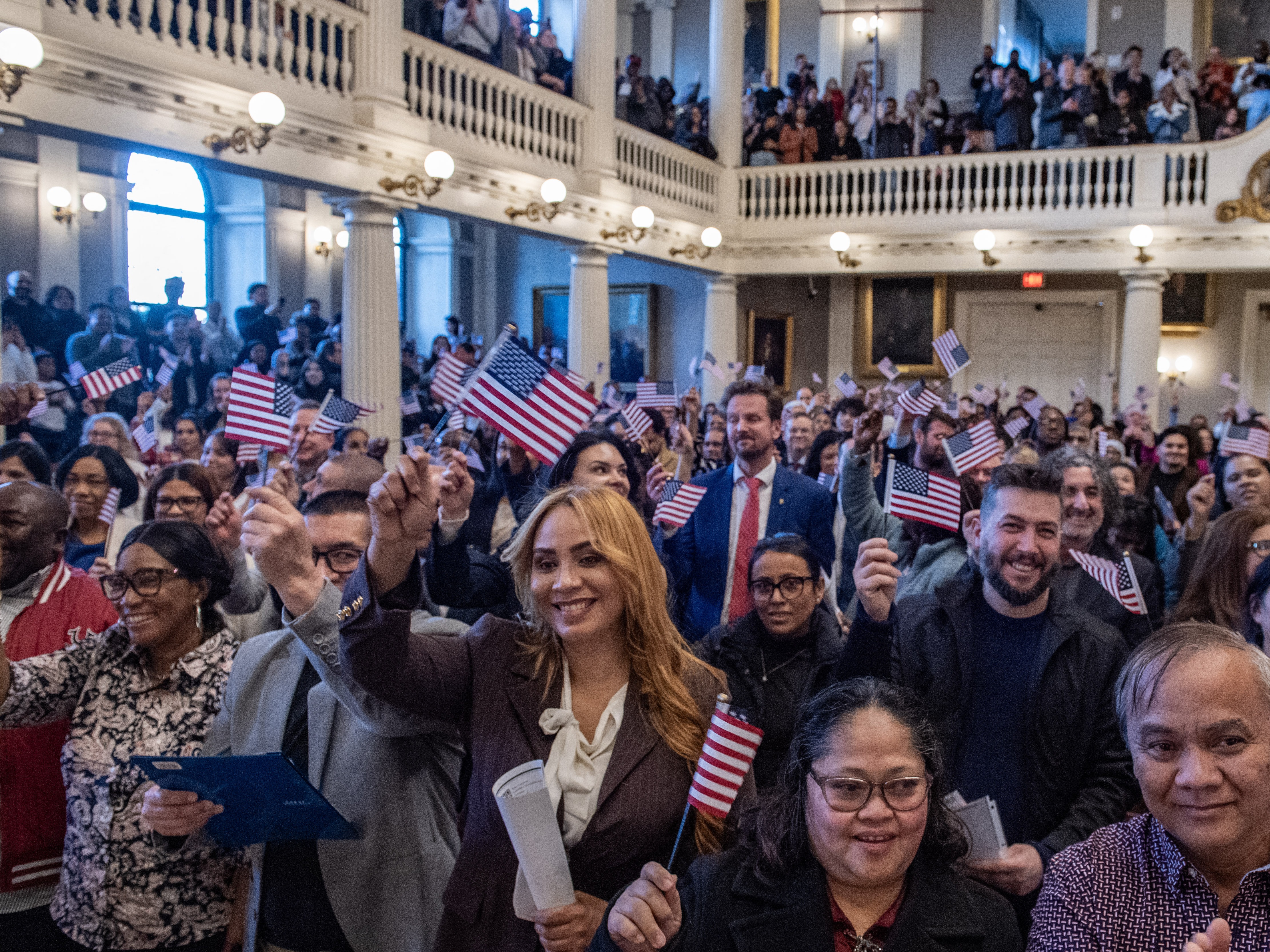 caption: New U.S. citizens take part in a naturalization ceremony at Faneuil Hall in Boston on Jan. 8.