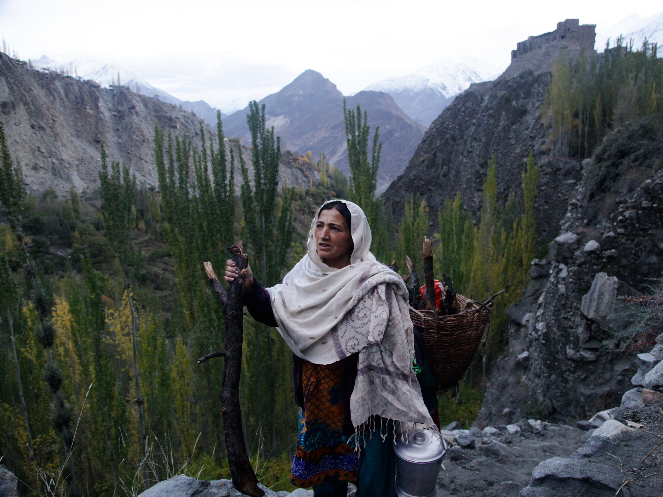 caption: Shamim Banno, 55, walks up the Harchi Valley after she finished milking her cow. Farmers in the Harchi Valley in Pakistan's highlands enjoyed a close relationship with their glacier that snakes between two mountain peaks.