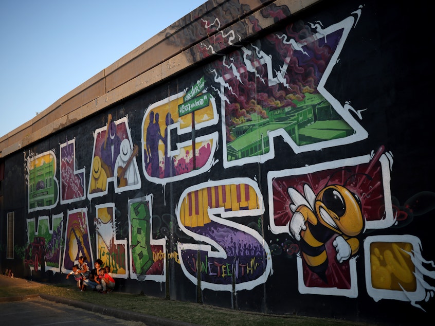 caption: A mural marking Black Wall Street, also called the Greenwood District, in Tulsa, Okla. The Tulsa Race Massacre in 1921 devastated Black Wall Street and claimed some 300 African American lives.