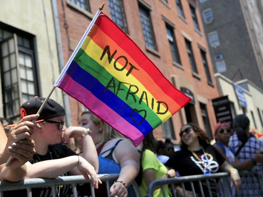caption: In this June 26, 2016, file photo, a woman holds a rainbow flag during the NYC Pride Parade in New York.