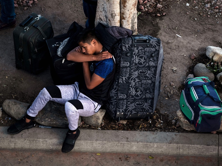 caption: An asylum-seeker rests outside El Chaparral port of entry while he waits for his turn to present himself to U.S. border authorities to request asylum, in Tijuana, Mexico, last month. A federal appeals court has granted the Trump administration's request to temporarily allow the government to continue to return asylum-seekers to Mexico while it appeals an ruling that blocked the policy.