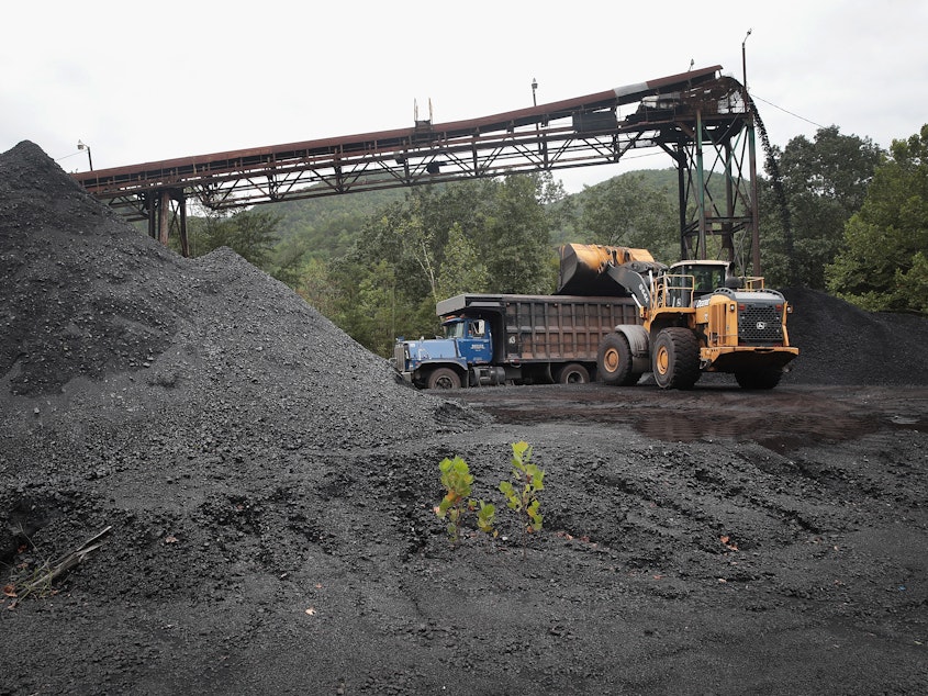 caption: A truck is loaded with coal at a mine on August 26, 2019 near Cumberland, Kentucky.