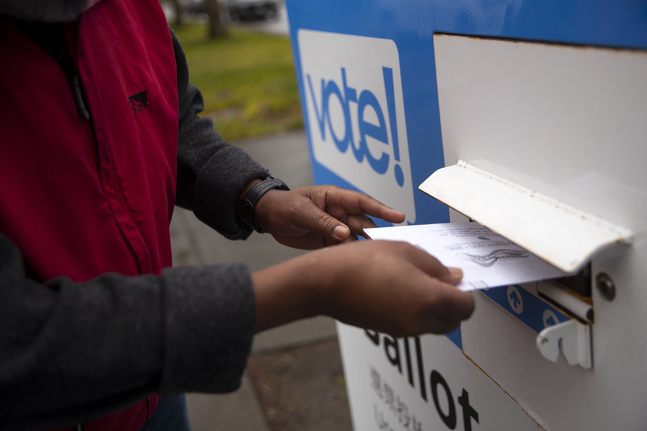 caption: Pastor Jeffrey L. Barker drops his ballot off ahead of the presidential primary on Monday, March 11, 2024, outside of the Beacon Hill Library in Seattle. 