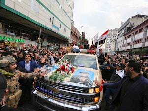caption: Mourners surround a vehicle carrying the coffins of Iranian Maj. Gen. Qassem Soleimani and Iraqi militia leader Abu Mahdi al-Muhandis, during a funeral procession Saturday in Baghdad. Both men were killed in a U.S. airstrike near the Iraqi capital's airport earlier this week.