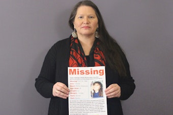 caption: Carolyn DeFord poses with the missing persons poster for her mother, Leona Kinsey, who went missing in October 1999.