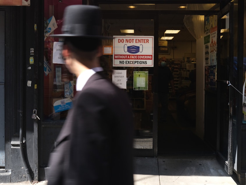 caption: Residents walk through the Brooklyn neighborhood of Borough Park on September 23 in New York City. Borough Park is one of numerous Brooklyn neighborhoods that are witnessing a spike in the number of COVID-19 cases.