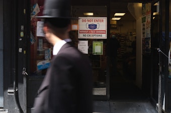 caption: Residents walk through the Brooklyn neighborhood of Borough Park on September 23 in New York City. Borough Park is one of numerous Brooklyn neighborhoods that are witnessing a spike in the number of COVID-19 cases.