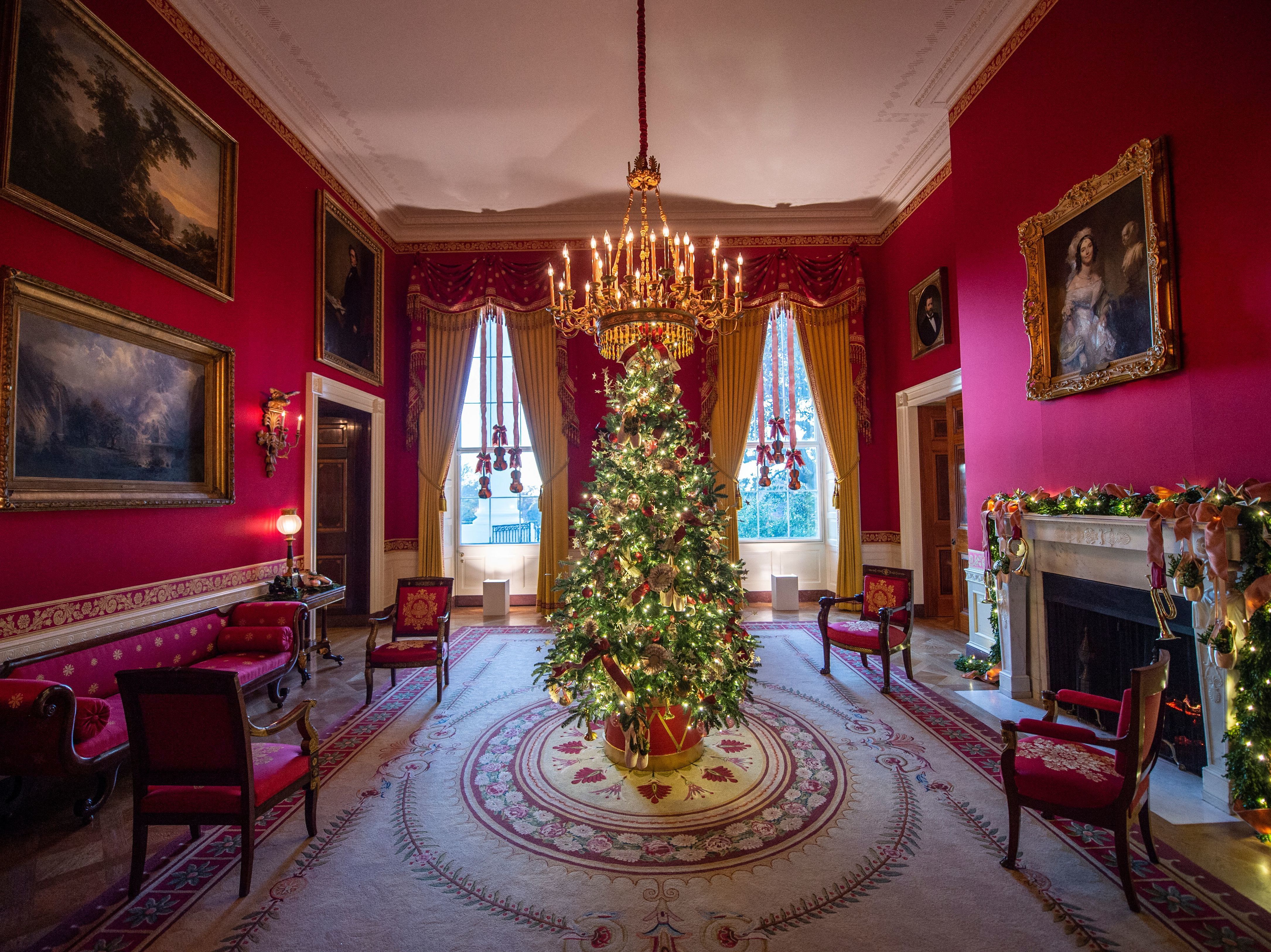 caption: A Christmas tree stands in the Red Room during a press preview of White House holiday decorations on Nov. 29.