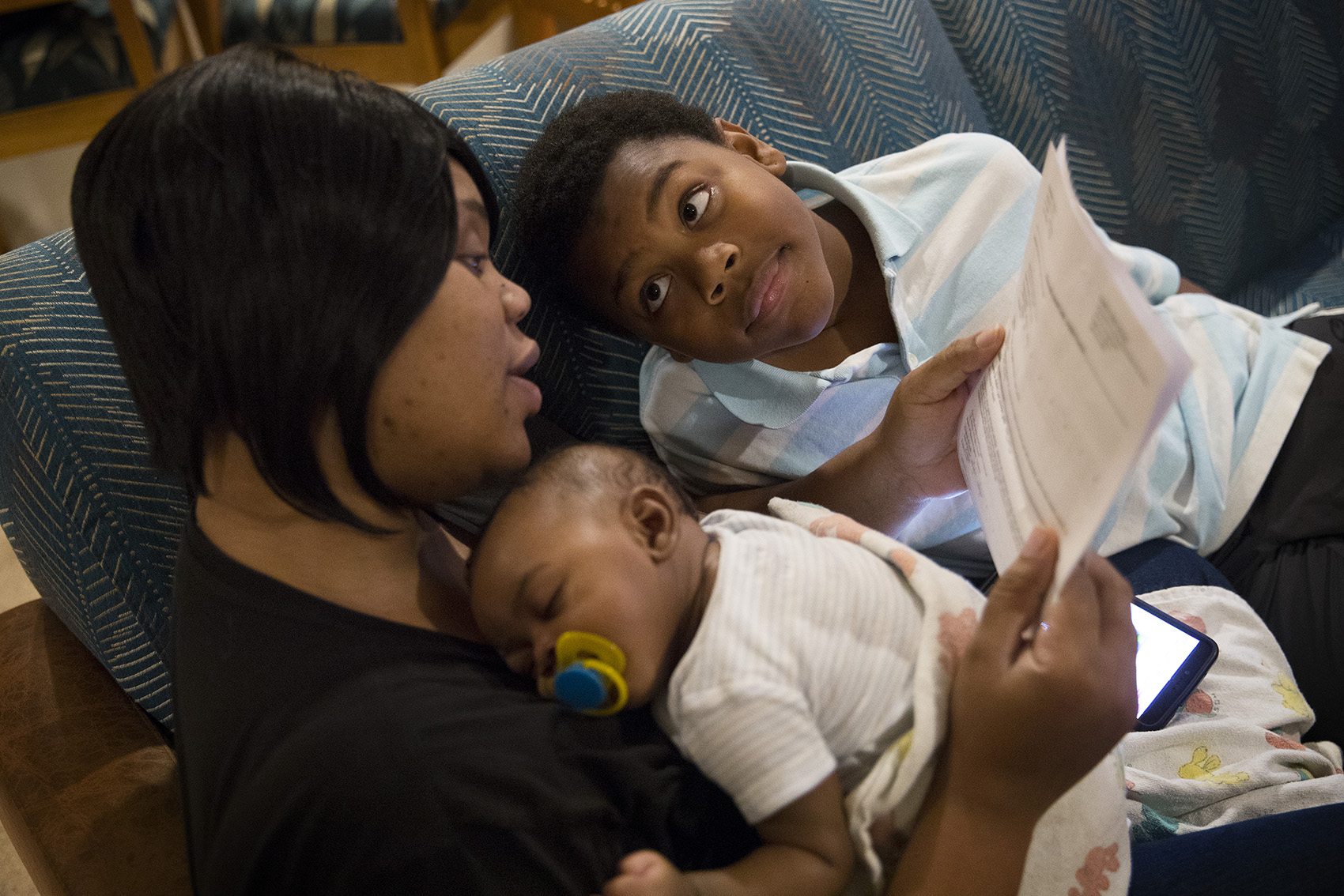 caption: Matthew Hicks looks at his mother Tiffany as she reads his report card on Wednesday, December 13, 2017, at their apartment in Auburn. Tap or click to see more photos of the family in their new home.
