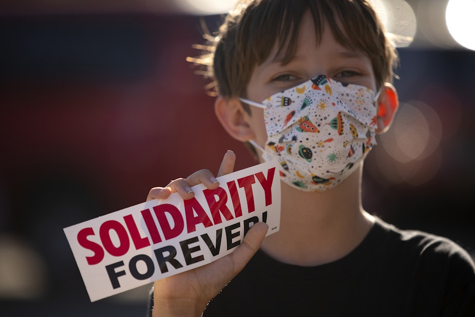 caption: August Hansen, 11, who will be starting 6th grade, joins Seattle Public Schools teachers for a rally on Tuesday, September 6, 2022, outside of Seattle Public Schools offices along 3rd Avenue South in Seattle. 