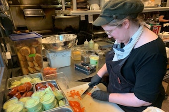 caption: Chef Lindsay Kucera prepares for dinner service at Jack Sprat, a small restaurant in the Alaska ski resort town of Girdwood. About one-third of the staff left during the pandemic.